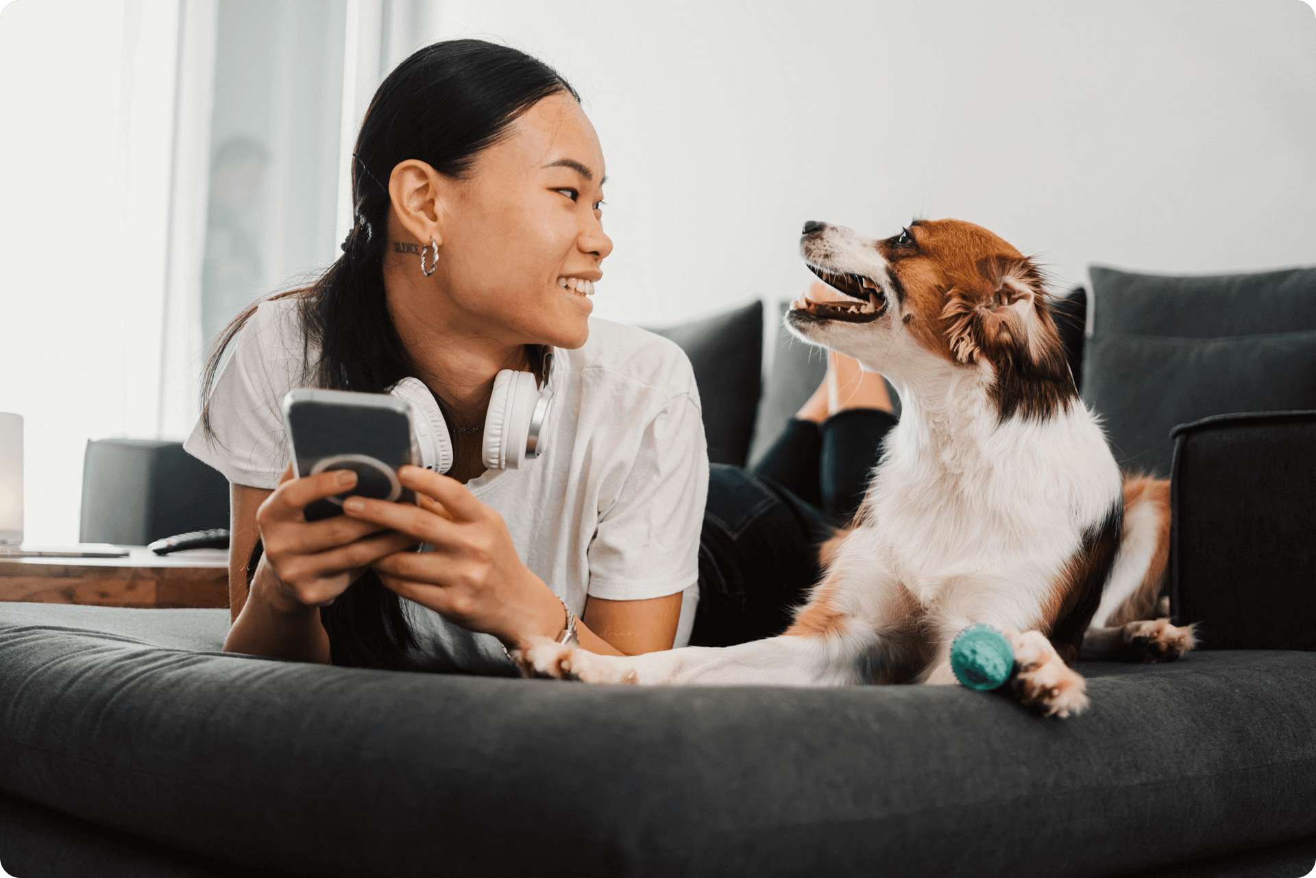 Woman and dog looking at each other while laying on the sofa